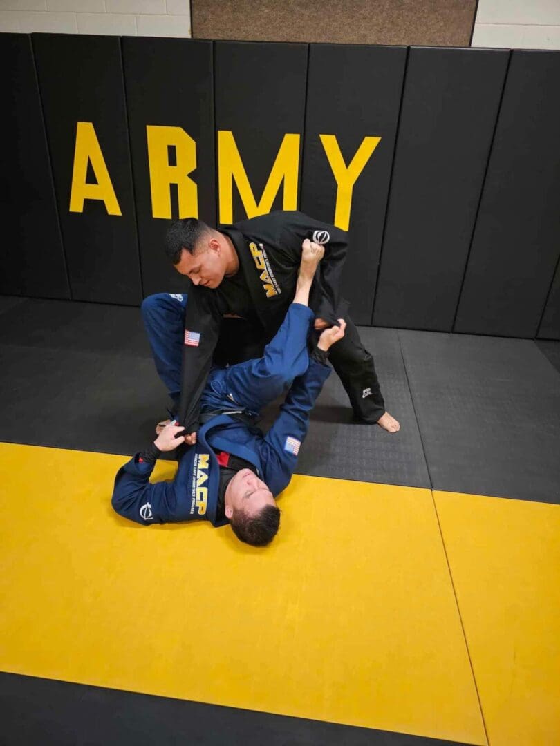 A man is doing a judo move on the ground