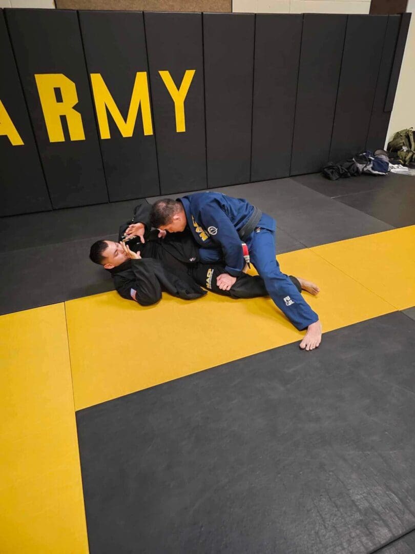 Two men are practicing jiu jitsu in a gym.