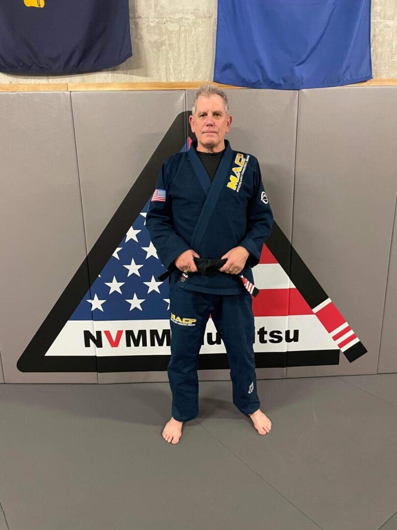 A man in blue uniform standing next to an american flag.